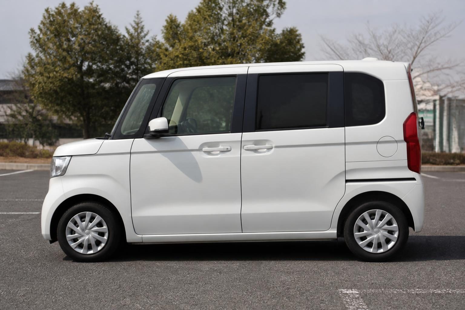 White Honda N-Box kei wagon shown in side profile in a parking lot.