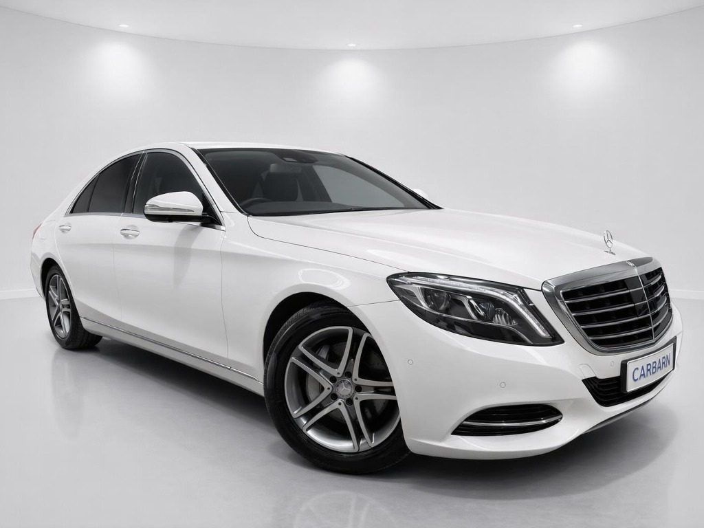 White Mercedes-Benz S-Class sedan photographed indoors from the front three-quarter angle.