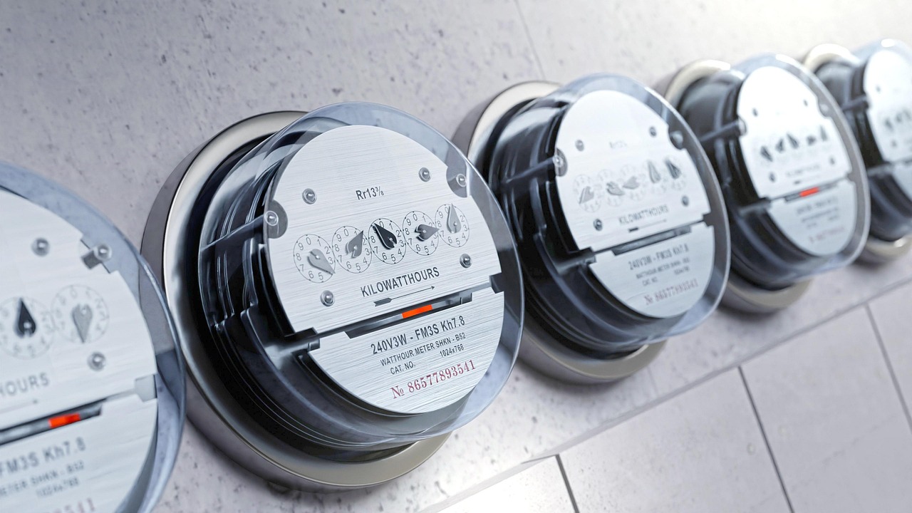 A row of analogue electricity meters displaying kilowatt-hour readings.