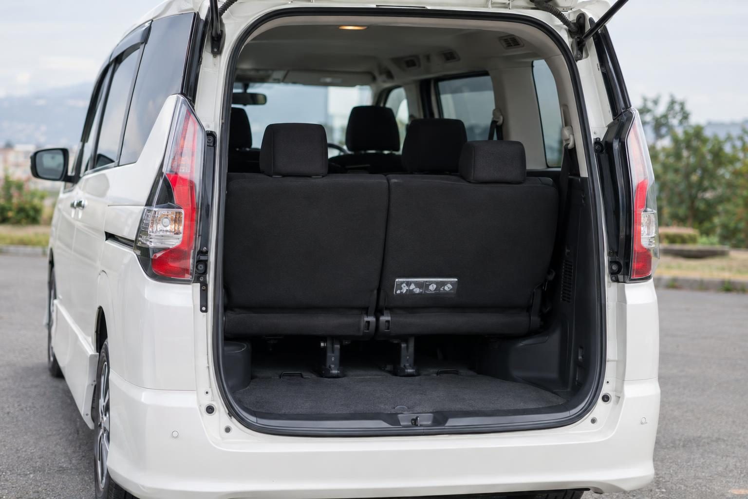 Rear-tailgate view into a people mover with a split third row and bench-style second row.