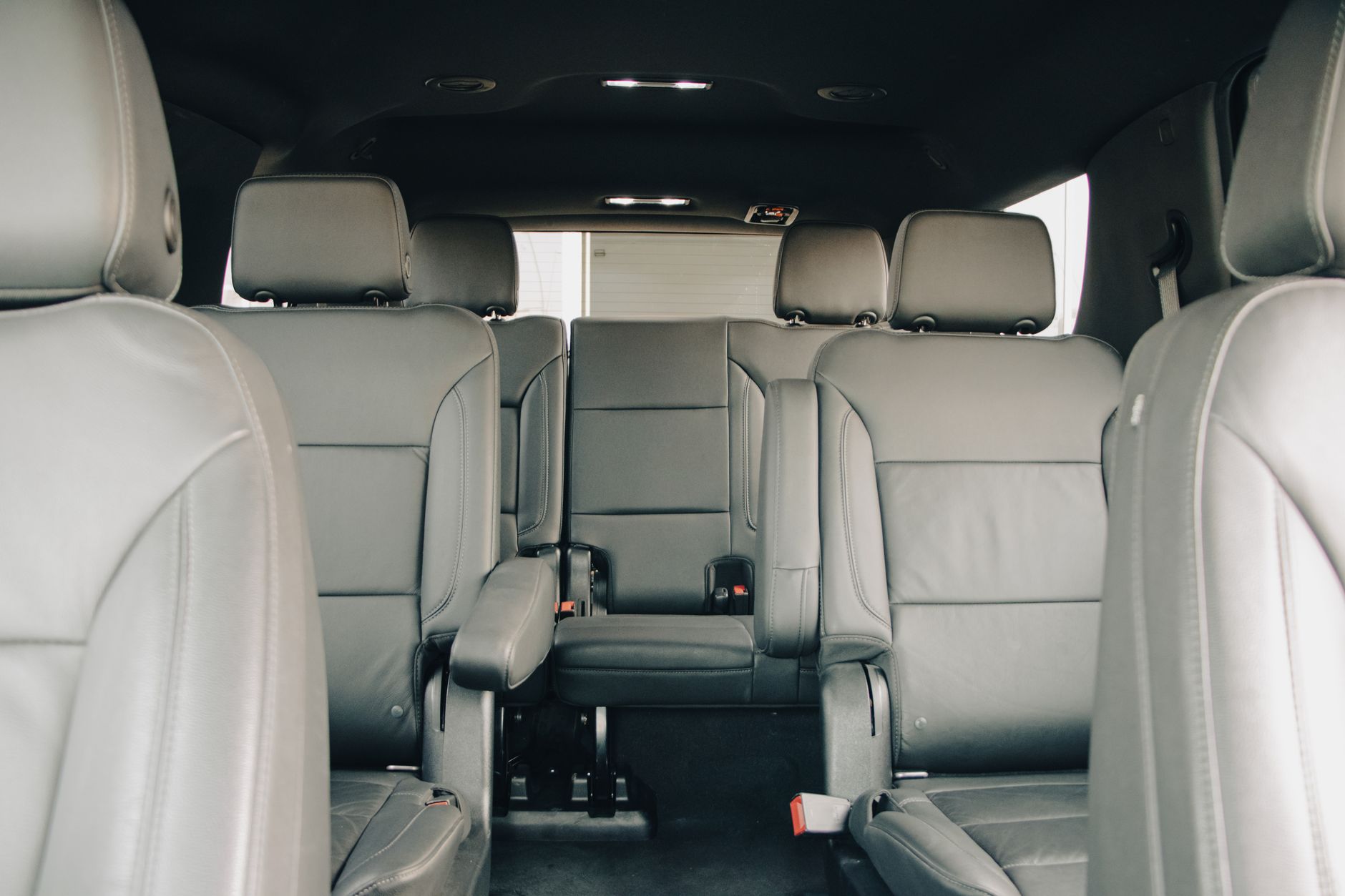 View through a minivan cabin showing gray second-row seats and a rear bench