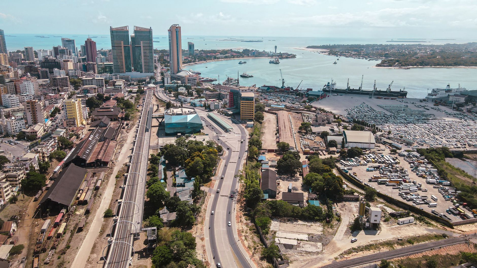 Aerial view of Dar es Salaam skyline, roads and harbour with ships and port facilities.