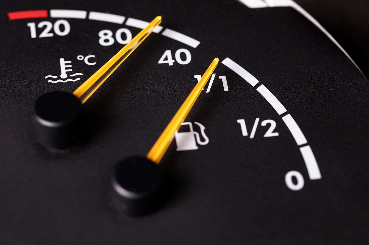 Close-up of dashboard fuel and temperature gauges with yellow needles.