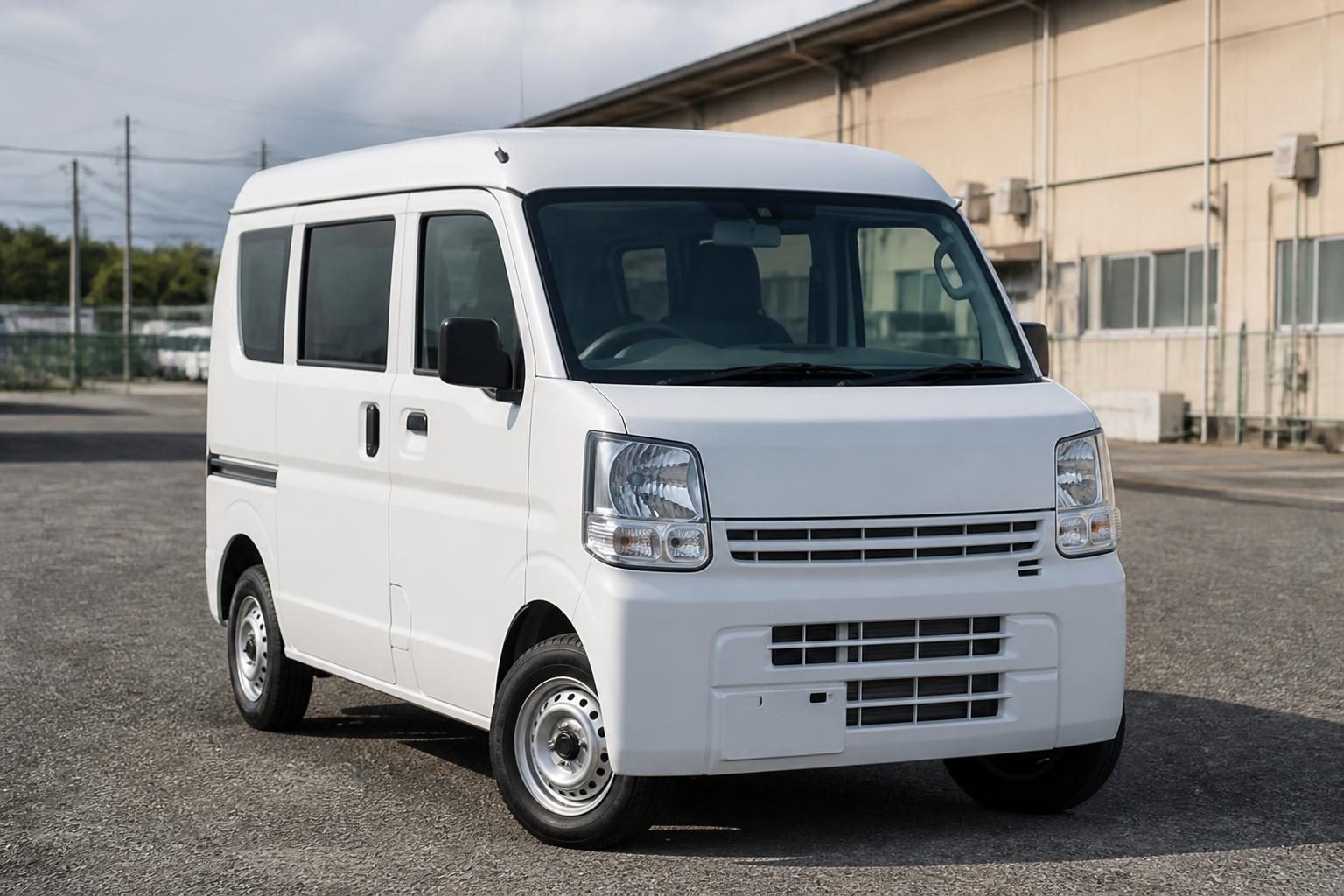 White Suzuki Every-style kei van parked beside an industrial building
