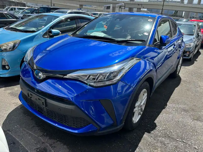 Blue first-generation facelift Toyota C-HR parked in a vehicle lot, viewed from the front.